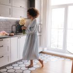 full-view-happy-woman-with-flowers-home_197531-33087